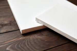 Two white blank canvases on brown wooden background. Mockup